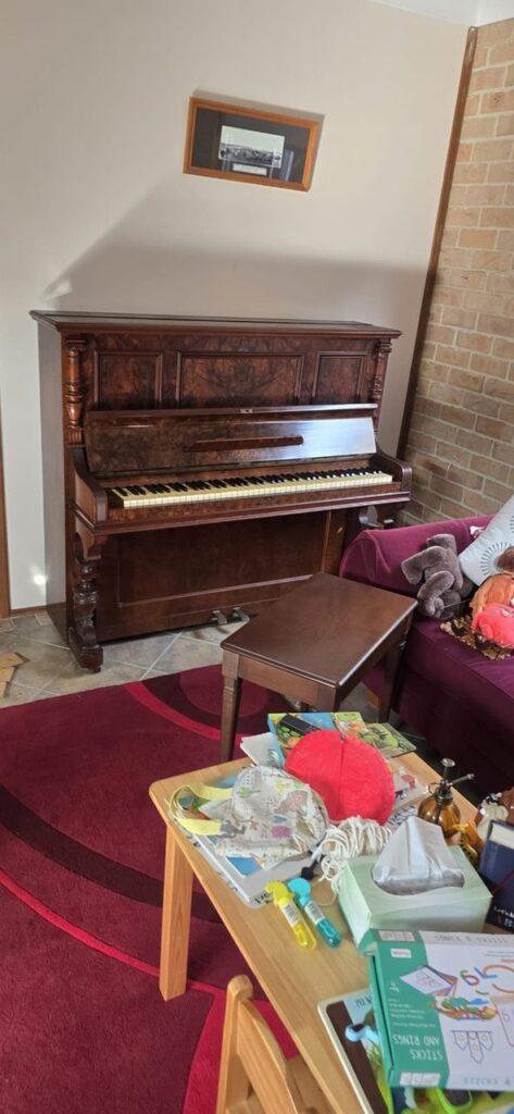 Upright piano before picking up from a home setting